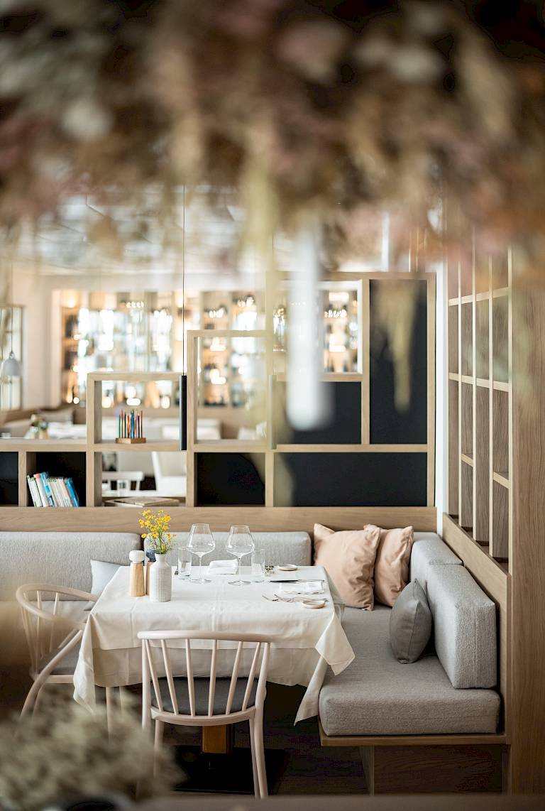 Ristorante elegante con tavolo apparecchiato, arredamento moderno e luce calda.