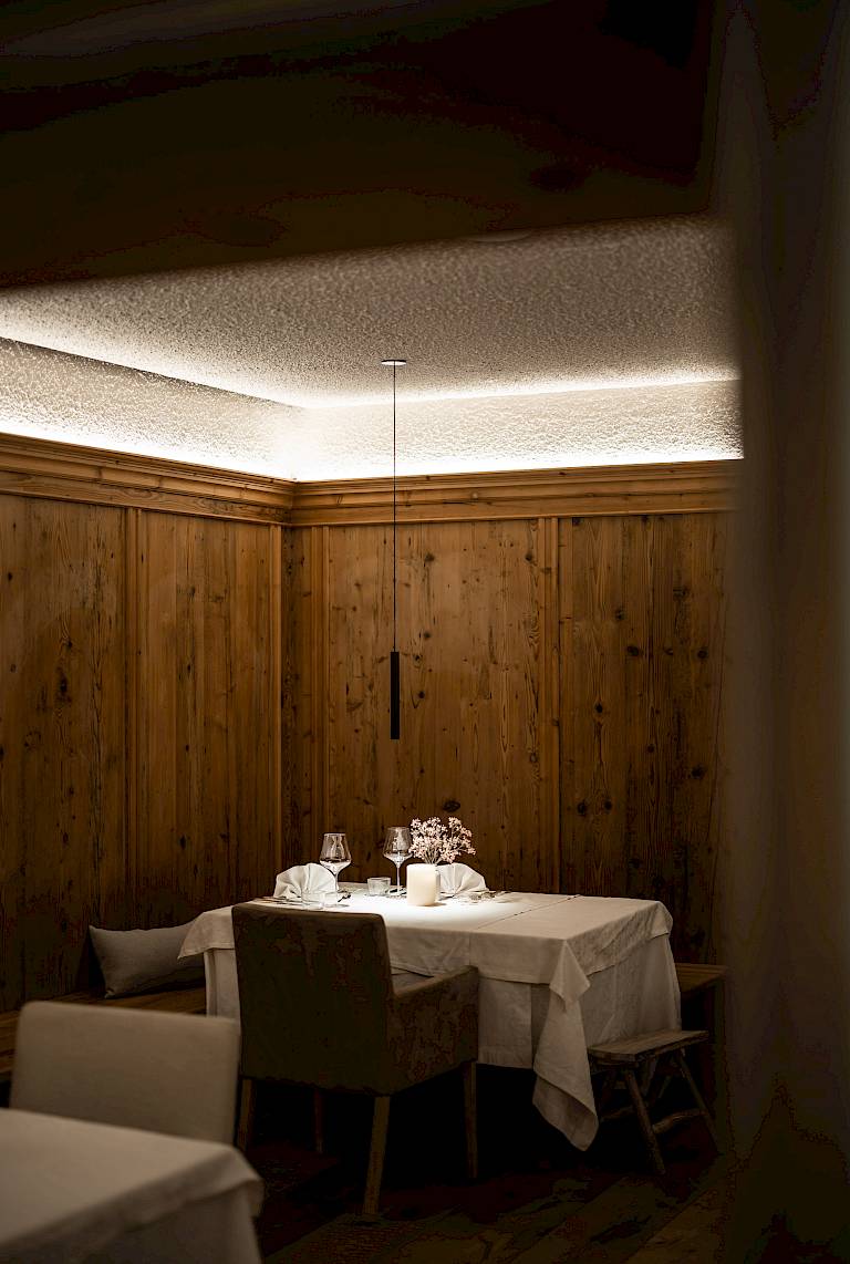 Ristorante elegante con pareti in legno, tavolo illuminato e sedie, pronto per gli ospiti.