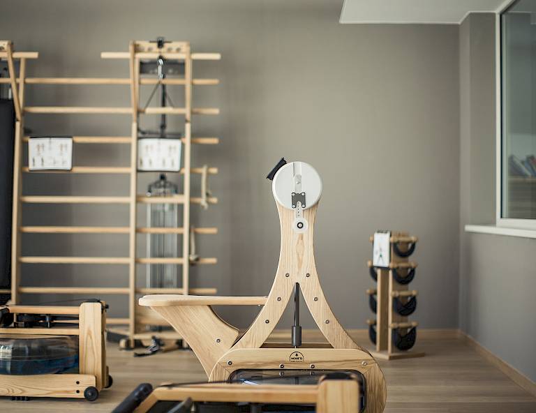 Una moderna palestra attrezzata con apparecchiature in legno e pesi in un design elegante e minimalista.