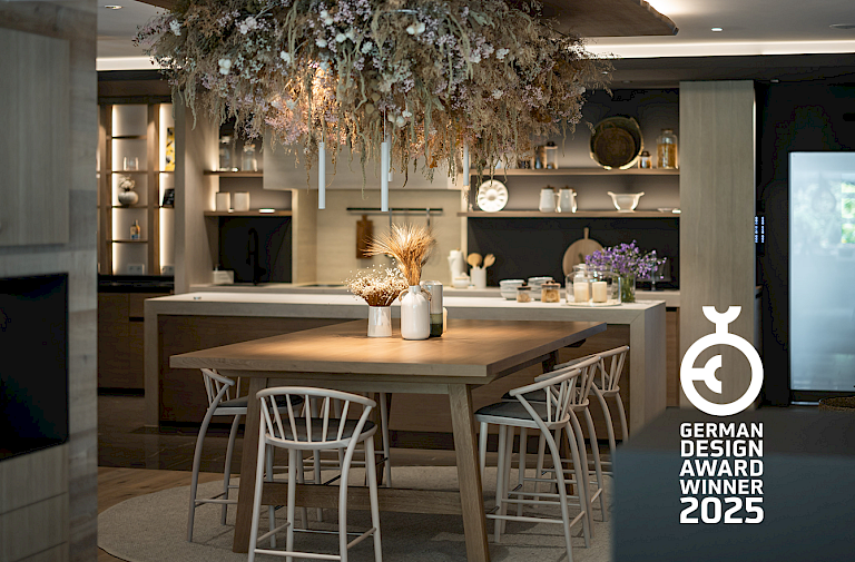 Moderne Küche mit Holzdekor, hängenden Pflanzen und Designpreis 'German Design Award Winner 2025'.